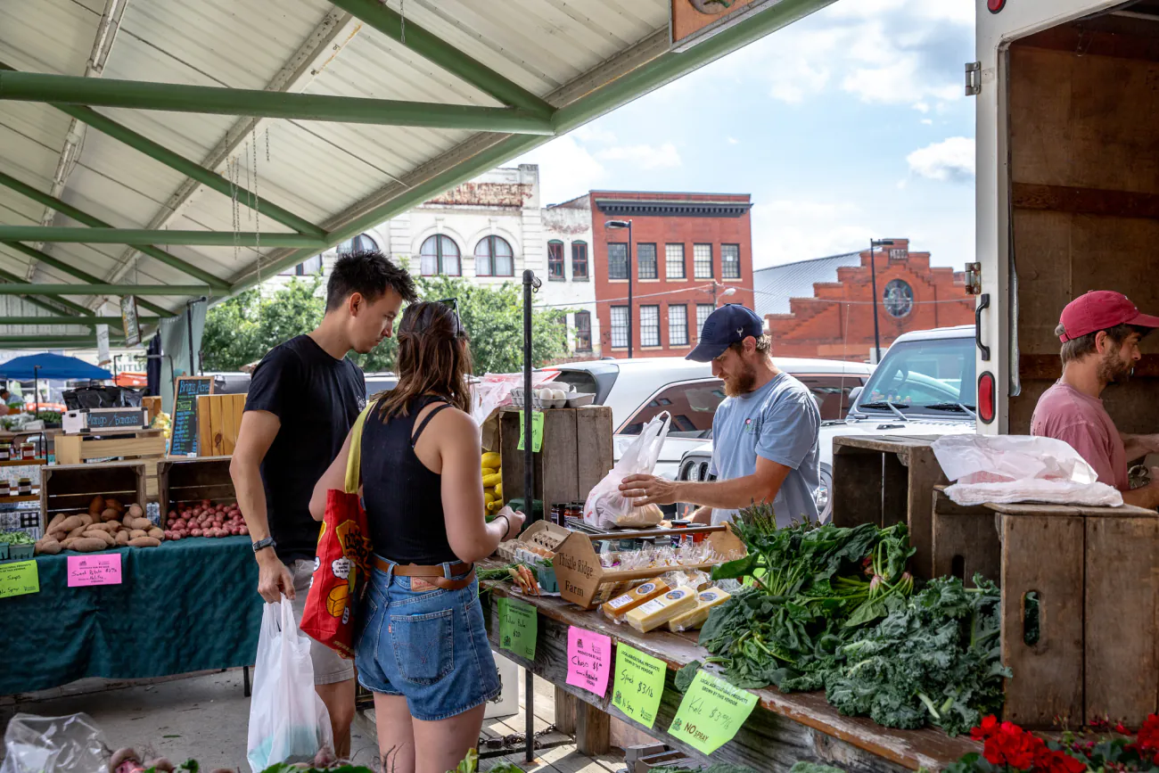 A couple buys fresh produce from a farm stand at the Lynchburg Community Market